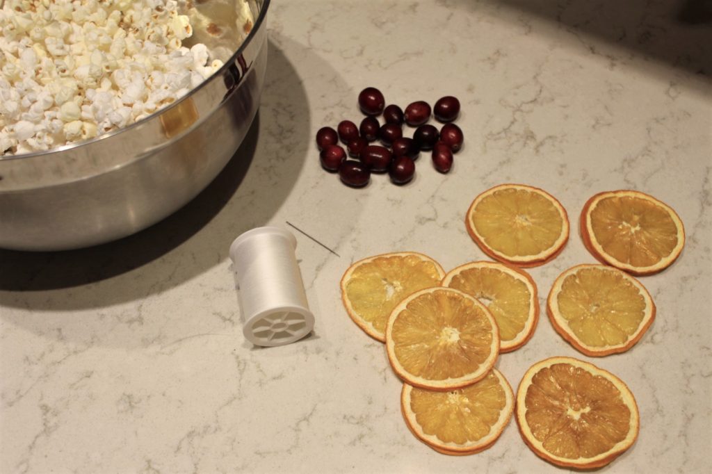supplies for making popcorn garland with cranberries and orange slices