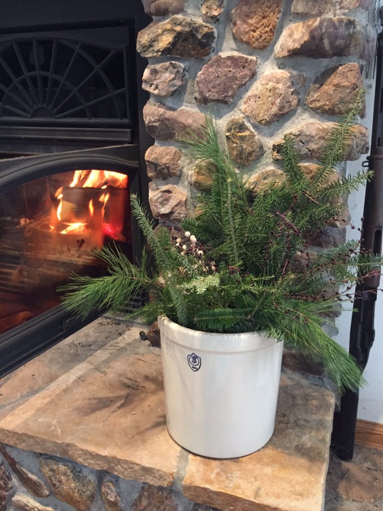 Crock decorated with pine bows for rustic Christmas look