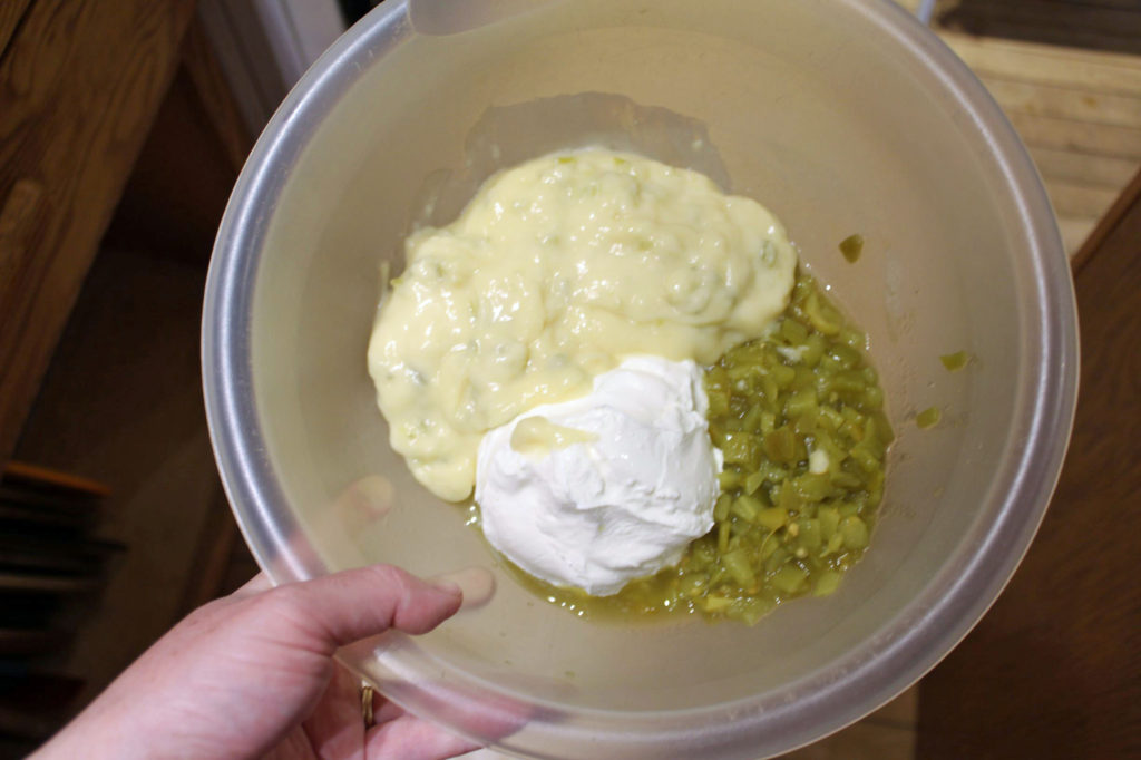 Mix cream of celery soup, 1 cup of sour cream, and green chilies together